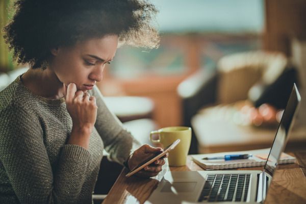 concerned woman looking at phone working from home