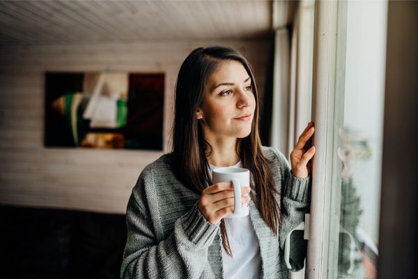 a woman looking outdoors, thinking pensively