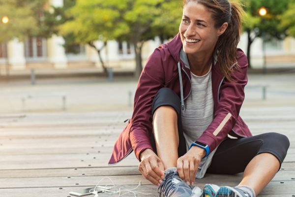 Female fitness runner getting ready for jogging outdoors in spring.