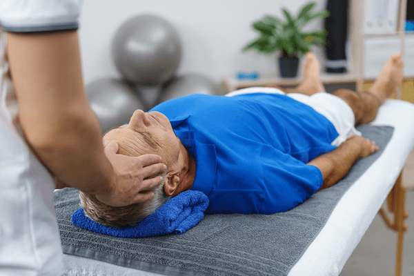 Man relaxing with a psychotherapist during head massage.