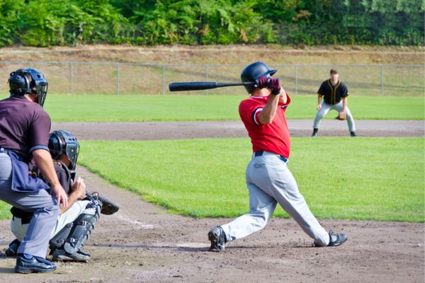 A group of people playing baseball outside