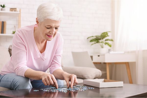 An elderly woman building a puzzle 