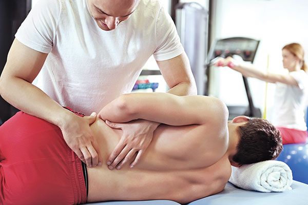 Man working on man with low back pain