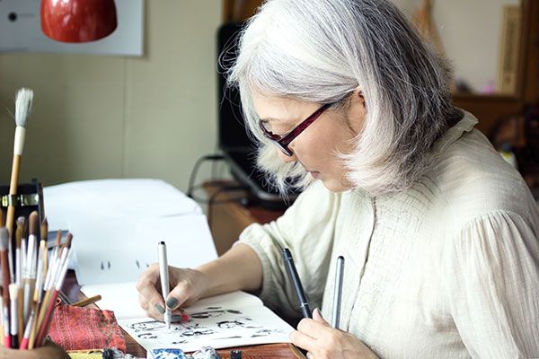 woman drawing in notebook